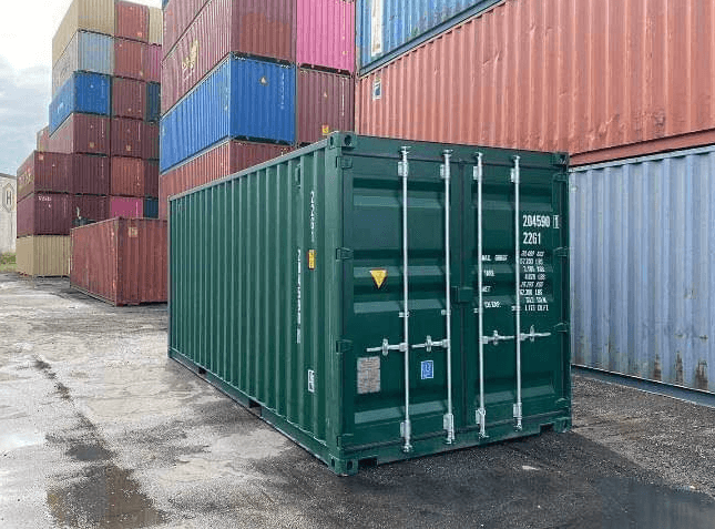 A used green shipping container standing in a storage yard