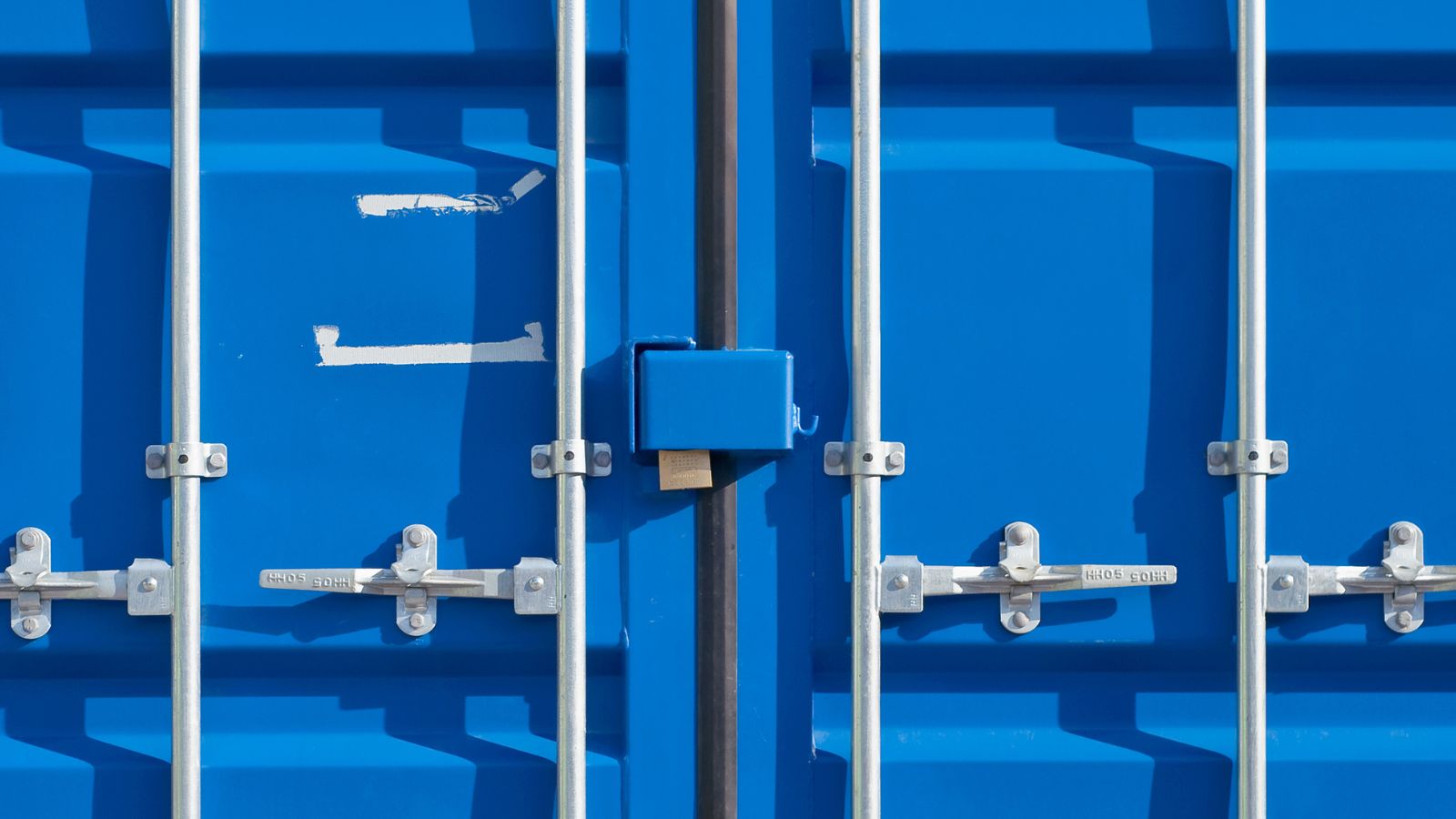 Blue shipping container cargo doors fitted with a steel lock box and four-bar locking gear