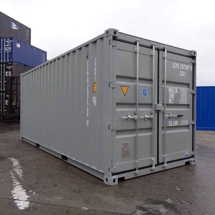 A one-trip 20ft shipping container in light grey with unmarked paint and square doors